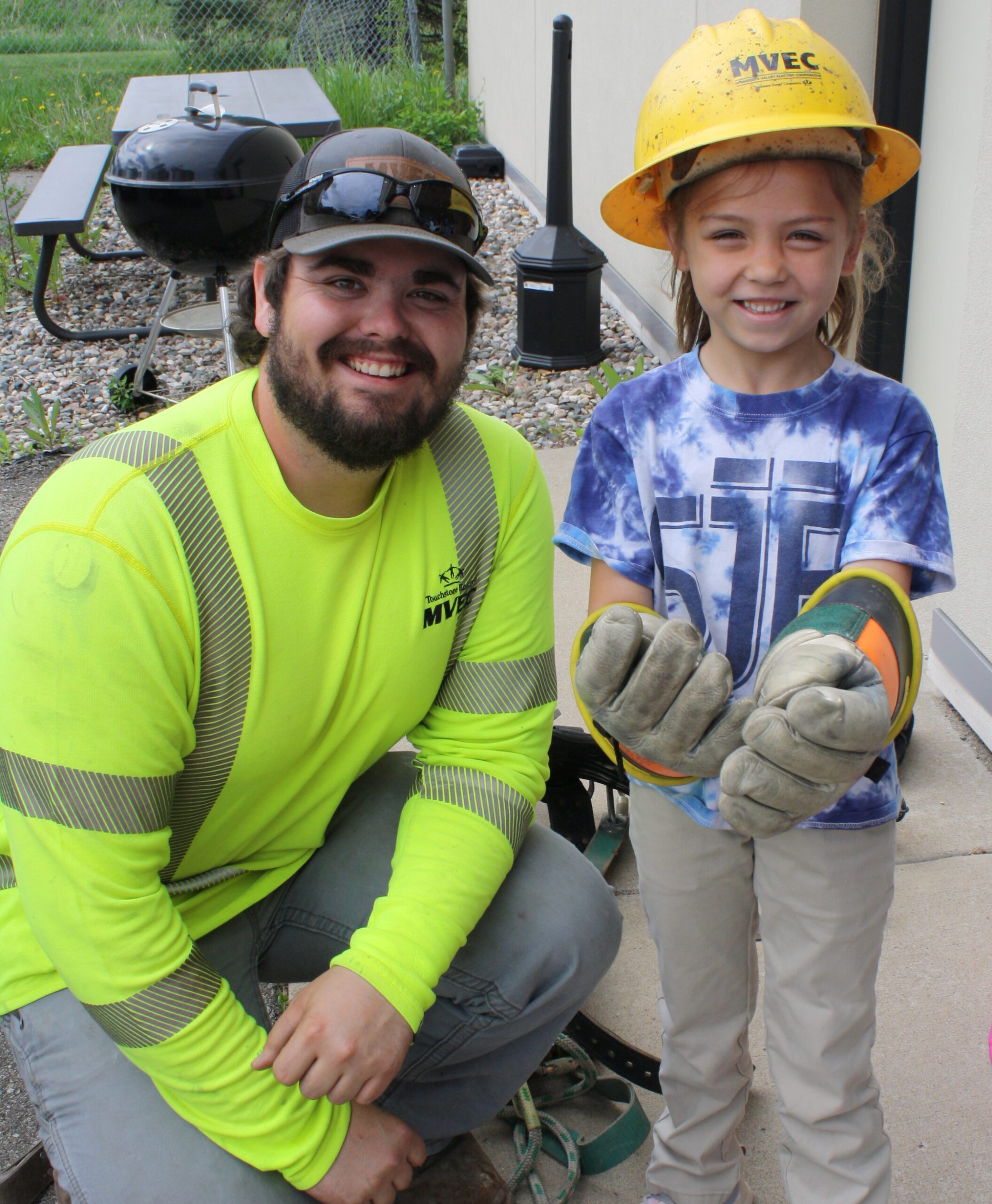 Electric Lineman with girl wearing hard hat